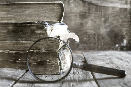 old scratched effect on photo magnifying glass and old bookの写真素材