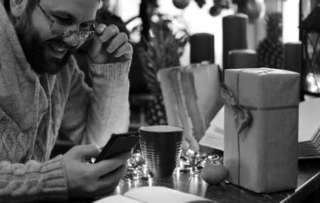 monochrome beard man writing christmas gifts on a tableの写真素材