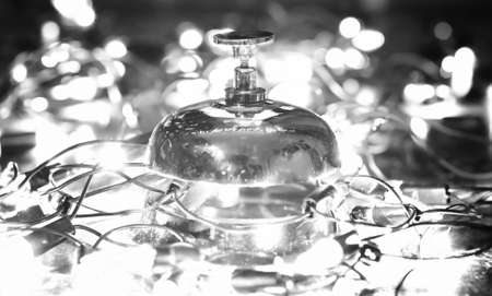 reception bell on the table and color shining garland on backgroundの写真素材