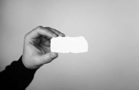 a small white piece of paper in his hand manの写真素材
