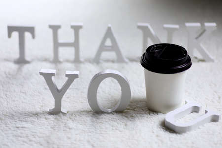 Wooden wthite letter Thank you on the crumpled carpet on the floorの写真素材
