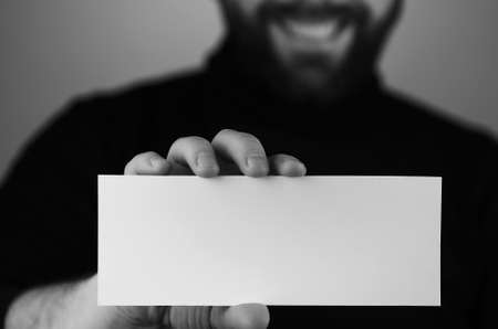 a small white piece of paper in his hand manの写真素材