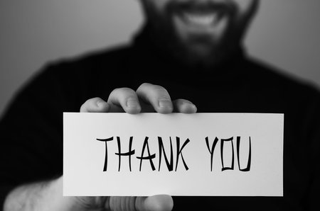 thank you on a small white piece of paper in his hand man