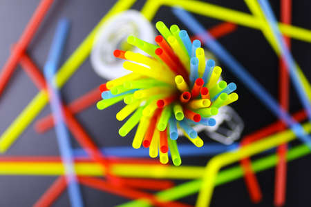 colored plastic cocktail tubes standing in a glass top viewの写真素材