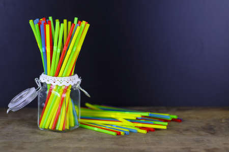 colored plastic cocktail tubes standing in a glass side viewの写真素材