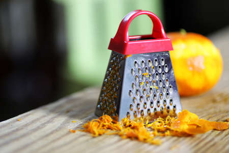 grater zest of citrus fruit and on the wooden tableの写真素材