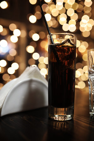 handsome man holding glass of alcohol with ice in a night clubの写真素材