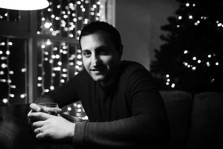 man holding glass of alcohol with ice in a night clubの写真素材