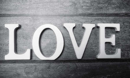 the word love made up of white wooden letters on a wooden backgroundの写真素材