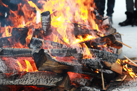 wooden logs burn with a bright flame in the fireの写真素材