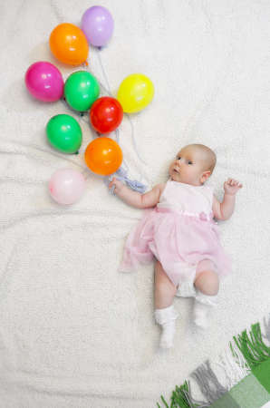 little girl holding a bunch of balloons and flight showsの写真素材