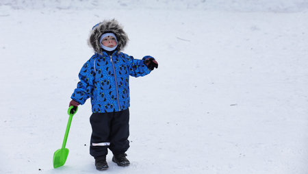 kids playing with snow in winter on backyardの写真素材