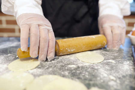 Male chef uses ingredients for preparing flour products on the kitchen tableの写真素材