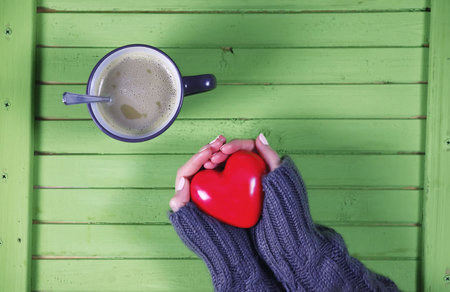 Girl drinking hot coffee and looks flower bouquetの写真素材