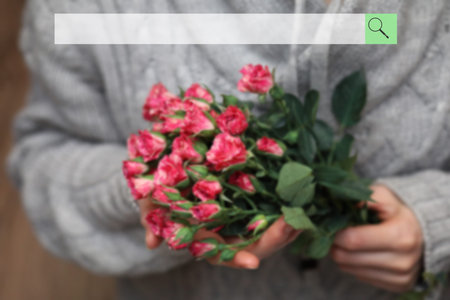 search bar on background of blurred bouquet of bush of roses in female handsの写真素材