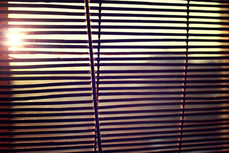 the sun is shining through the blindsの写真素材