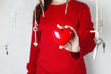 woman stretches out his hand with a shape of red heart