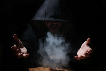 man in a black hood with cristal ballの写真素材