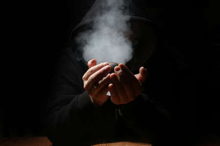 man in a black hood with cristal ballの写真素材