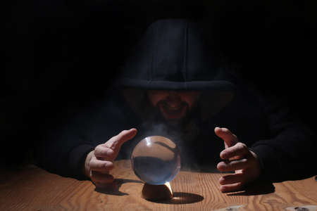 man in a black hood with cristal ballの写真素材