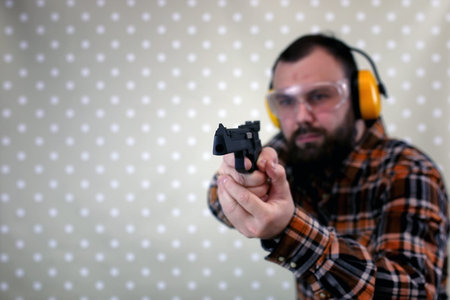 man with put on protective goggles and ear training in pistol sh