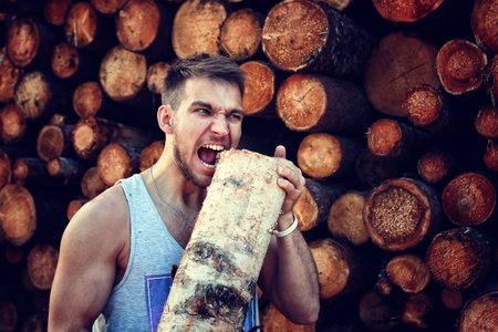 bearded person near timber pile wood