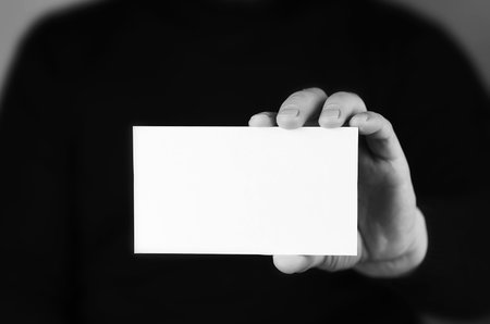small white piece of paper in his hand man monochromeの写真素材