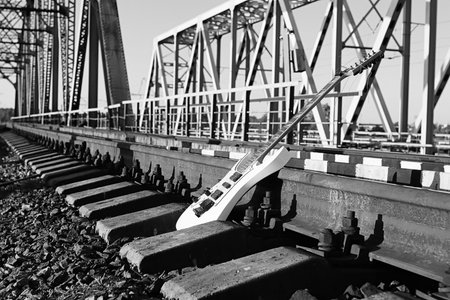 black and white electric guitar on the railroad tracks and stone