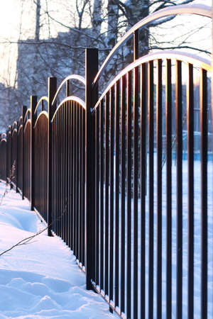 winter landscape iron fence at sunsetの写真素材