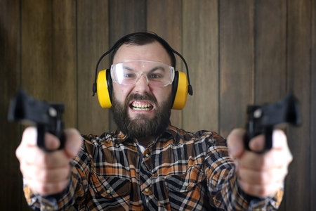 man with put on protective goggles and ear training in pistol sh