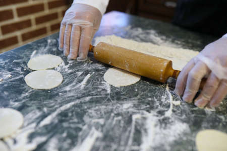 Male chef uses ingredients for preparing flour products on kitchの写真素材