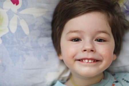 Portrait of a young child lying on a pillowの写真素材