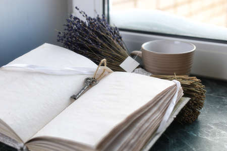 Vintage notebook on green marble windowsill opened with blank paの写真素材