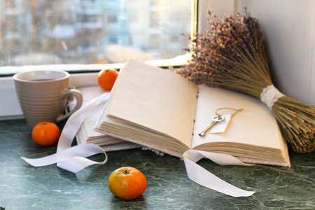 tangerines and vintage books on a marble table by the windowの写真素材