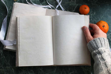 pages opened vintage book on green marble countertopの写真素材