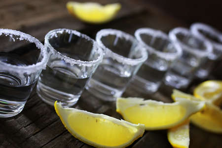 stack of tequila with salt and lemon on a wooden backgroundの写真素材