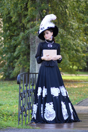 renaissance woman with book on the bridge in the park