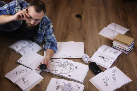 man working with book on the floorの写真素材