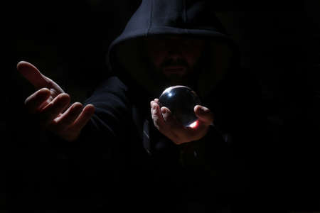 man in a black hood with cristal ballの写真素材
