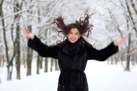 woman walking in winter snow-covered parkの写真素材