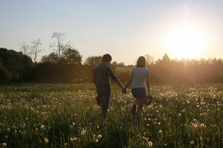 couple of young people walking in the sunset spring evening in aの写真素材
