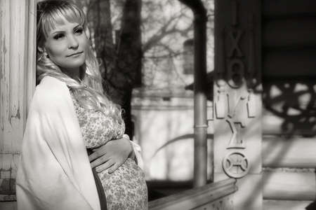 pregnant girl walking around the city park in early springの写真素材