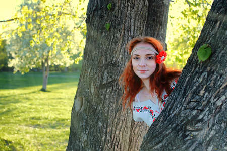 Girl in the spring walks through the apple alley in the eveningの写真素材