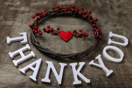 red santa hat on textured wooden background and Thank you woodenの写真素材
