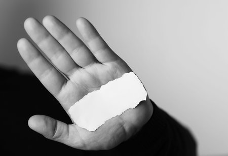 Small white piece of paper in his hand man monochromeの写真素材