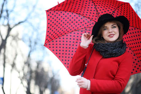 Pretty girl on a walk with an umbrella in the cityの写真素材