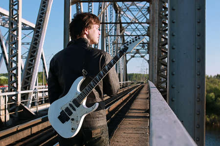 Man with an electric guitar in the industrial landscape outdoorsの写真素材