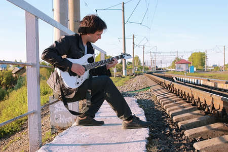 Man with an electric guitar in the industrial landscape outdoorsの写真素材