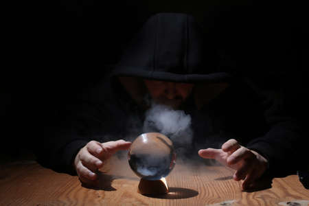 man in a black hood with cristal ballの写真素材