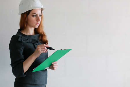 female architect at the construction site with drawings and noteの写真素材